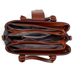 Detail of brown faux leather handbag with triple compartments and metal zip closure