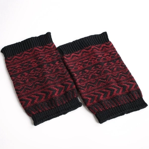 Détail du motif géométrique rouge et noir sur les jambières en tricot épais