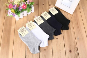 Set di cinque paia di calze corte in cotone in colori neutri su un tavolo di legno
