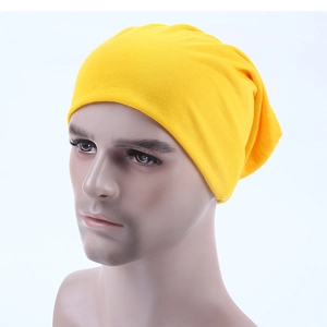 Side view of a bright yellow knitted slouchy beanie hat displayed on a mannequin head