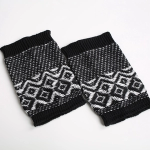Detail of black and white geometric jacquard knit leg warmers with ribbed edges