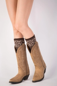 Detail showing embroidered patterns on tan suede western boots with knit leg warmers