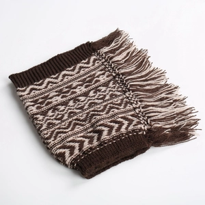 Close-up of brown and beige geometric jacquard knit leg warmer with decorative fringe