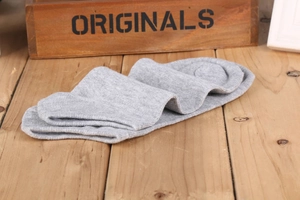 Dettaglio della trama di calze in cotone grigio presentate su una scatola di legno vintage