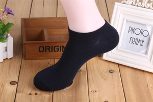Calzini bassi uomo in cotone blu navy indossati su modello su pavimento in legno