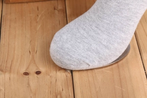 Dettaglio della cucitura della punta e trama a maglia dei calzini in cotone grigio