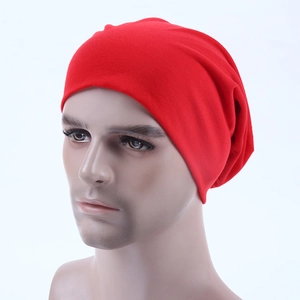 Close-up of bright red knitted slouchy beanie with soft texture on a male mannequin head