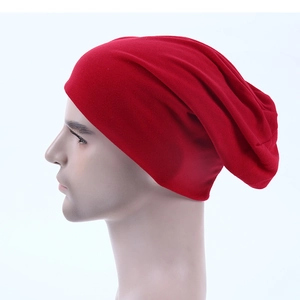 Detail shot of the red slouchy knit beanie showing fabric texture and drape on person