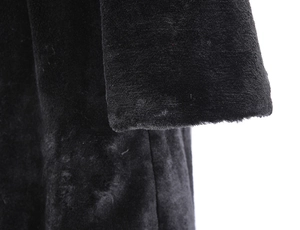 Close-up of black faux fur sleeve and plush texture on long winter hooded coat