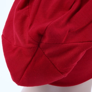 Close-up of red knit beanie fabric texture and reinforced top stitching detail
