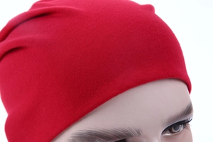 Close-up of red knit beanie showing detailed fabric texture and premium weaving