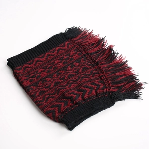 Detail of red and black geometric jacquard knitted leg warmer with dense fringe edges