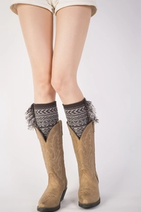Detail of ethnic knit leg warmers with tassels paired with vintage brown leather boots