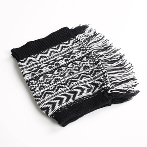 Detail of knit leg warmers with black and white geometric wave patterns and fringe trim