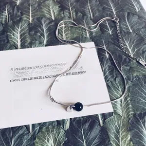 Detail of silver snake chain necklace with black onyx and polished silver beads