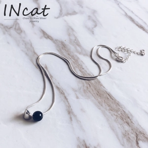 Detail of 925 sterling silver snake chain with black onyx bead and silver cone pendant
