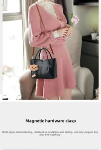 Detail of the high-quality magnetic snap closure and golden hardware on the black tote bag