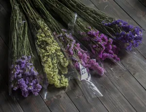 Dried Myosotis flower bouquets in purple and yellow on wood floor for home decor