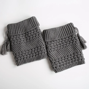 Detailed knit texture and fringe accents on dark grey winter leg warmers