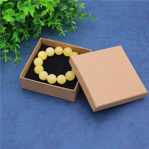 Square brown kraft paper jewelry gift box with black foam insert and beaded bracelet