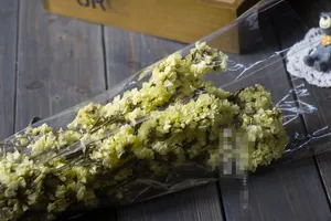 Detail view of premium yellow dried Statice flowers in professional plastic packaging