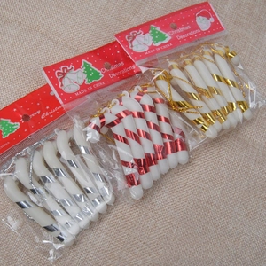 Detailed view of red, gold and silver striped Christmas candy cane ornaments on burlap
