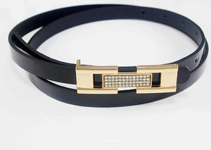 Vue détaillée d'une ceinture fine en cuir verni noir avec boucle dorée en strass
