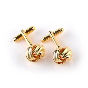 Detailed close-up of golden twisted knot cufflinks with polished finish and T-bar clasp