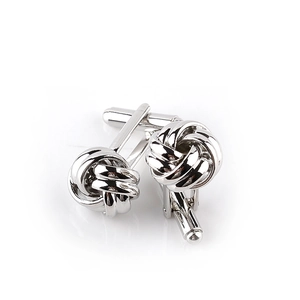 Close-up of polished silver knot cufflinks with a classic twisted design and T-back closure