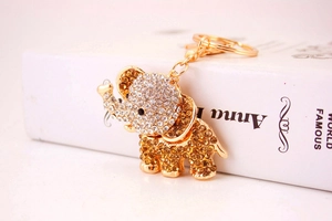 Close-up of golden elephant keychain with sparkling clear and amber rhinestones