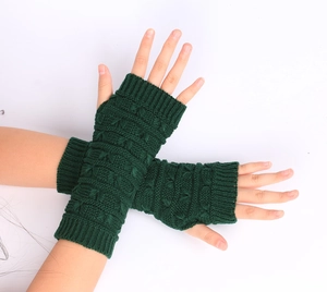 Detail of dark green cable knit arm warmers and fingerless gloves with soft texture