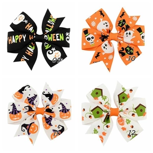 Detail of four Halloween themed grosgrain ribbon hair bows with ghosts and pumpkins