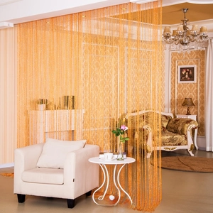 Close-up of golden shimmer fringe curtain used as a stylish room divider in a living room