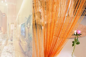 Detail of orange flat silver thread curtain with sparkling polyester fringe texture