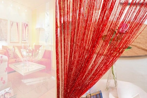 Detail of high-density bright red door curtain with silver glitter threads and drape