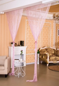 Close-up of a decorative pink string curtain partition with a sleek glossy silk texture