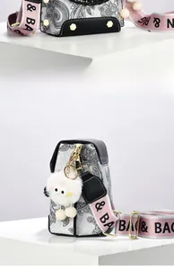 Detail of bohemian paisley print handbag with pink woven strap and white monster charm