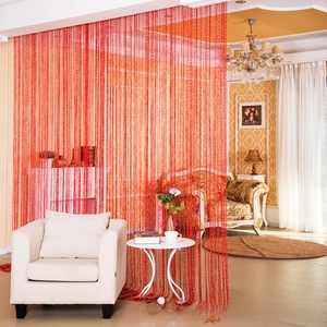 Detail showing red glittering string curtain divider in a warm living room home setting
