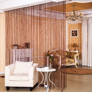 Detail of shimmering bronze tassel curtain for elegant room division in living room