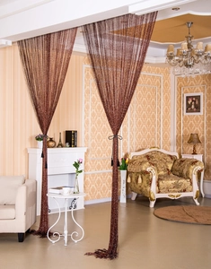 Detailed close-up of brown fringe curtain panel with shimmering silver threads for room decor
