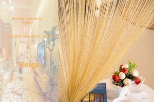 Macro detail of cream-colored polyester string curtain with sparkling silver silk threads