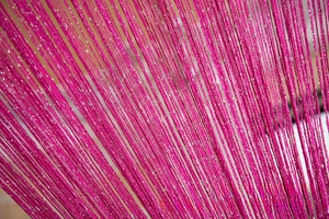 Detail of rose pink door string curtain featuring woven metallic silver threads for decor