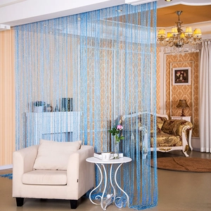 Detail of blue shimmering string curtain used as a decorative room divider in a living room