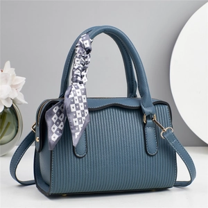 Close-up of navy blue handbag with vertical stripes embossing and heart pattern scarf