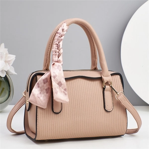 Elegant dusty pink textured leather handbag with decorative scarf and shoulder strap
