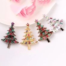 Macro detail of Christmas tree brooches with colorful rhinestones in four metal finishes