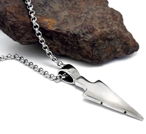 Detailed macro view of a silver arrow pendant on a sleek metal keel chain for men