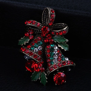 Detailed view of vintage gold Christmas bell brooch with red and green rhinestones