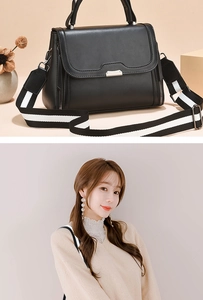 Close-up of black crossbody bag featuring a silver buckle and striped woven shoulder strap