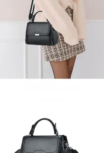 Close-up of black crossbody bag with gold buckle and wide color-block shoulder strap